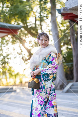 A young woman in formal attire praying at a shrine A young woman in formal attire praying at a shrine 119834740