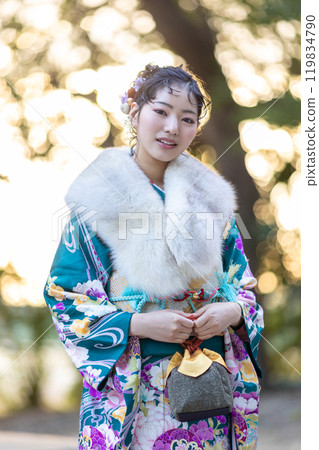 A young woman in formal attire praying at a shrine A young woman in formal attire praying at a shrine 119834790