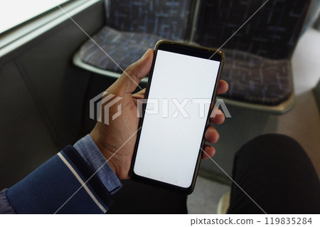 passenger sitting in a bus using his phone. 119835284