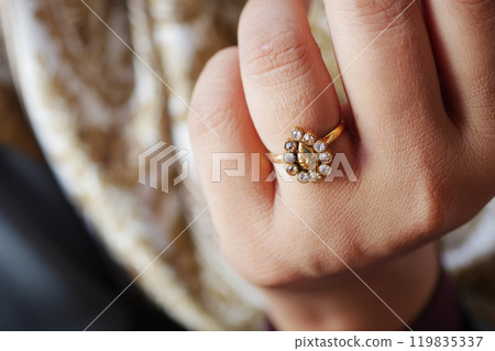 This is an Elegant Gold Ring featuring exquisite Gemstone Accents set on a Delicate Hand This is an Elegant Gold Ring featuring exquisite Gemstone Accents set on a Delicate Hand 119835337