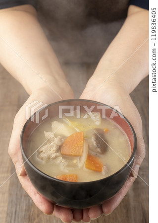 Holding steaming miso soup in hands, serving food 119836405