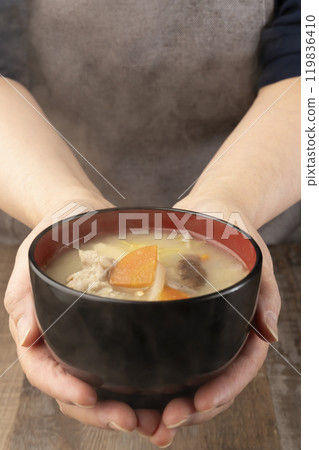 Holding steaming miso soup in hands, serving food Holding steaming miso soup in hands, serving food 119836410