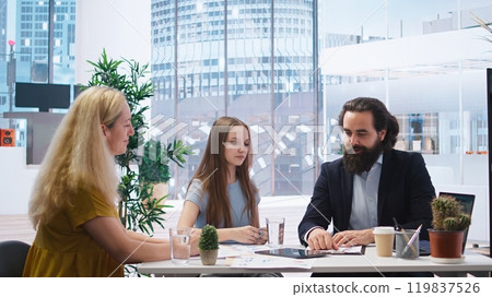 Welcoming financial advisor meeting with clients to recommend financial products and investments, greeting them. Investment strategies expert in workspace doing handshake with customers, camera A 119837526