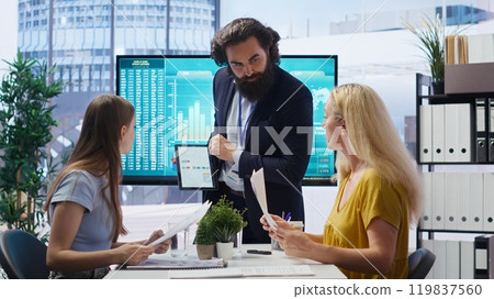 Financial adviser conducting audit of clients income to create plan helping them build futureproof saving habits. Agent talking with parent and gen Z girl, offering advice on investing, camera B 119837560