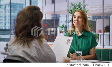During a structured job interview, applicant presents her cv to a business recruiter, elaborating on their career history and aspirations. Career development within the enterprise. Camera A. During a structured job interview, applicant presents her cv to a business recruiter, elaborating on their career history and aspirations. Career development within the enterprise. Camera A. 119837601