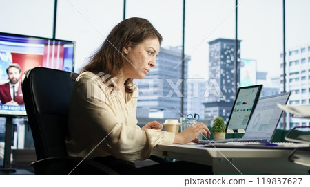 Ambitious female leader developing a new business plan, showcasing her expertise in target analysis, strategic thinking and commitment to achieving company objectives. Decision making. Camera A. 119837627