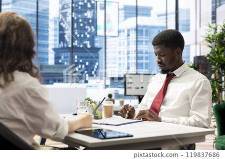Recruiter in office meeting with african american man after finding best talent to fill open company position. Human resources employer hired to assess skills of candidate 119837686