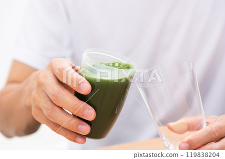 Male hand holding green juice 119838204