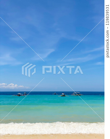 Fishing boats over the sea surface. Ocean waves on beach resort. Samal Island. Davao, Philippines. Fishing boats over the sea surface. Ocean waves on beach resort. Samal Island. Davao, Philippines. 119839531
