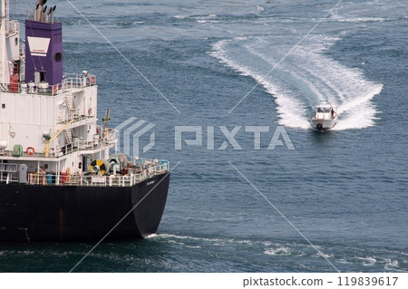 A ferry boat bypassing cargo ships passing through the Kurushima Strait 119839617
