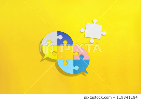 Two overlapping colorful puzzle bubbles with the center piece missing on an orange background 119841184
