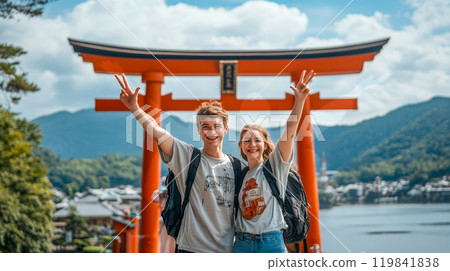 A young couple of foreign tourists standing in front of a torii gate 119841838