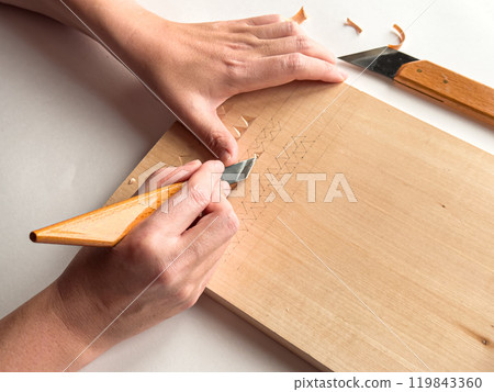 Woodworking craftsmanship. Precision carving techniques on wooden surface Woodworking craftsmanship. Precision carving techniques on wooden surface 119843360