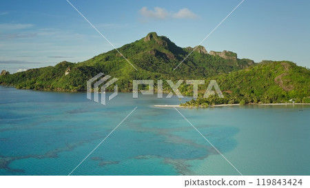 Stunning beauty of Maupiti tropical island, white sand beach and green jungle forest mountain, turquoise coral reef lagoon. Remote wild nature exotic summer vacation travel background. Aerial view 119843424