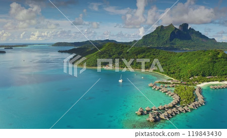 Turquoise lagoon water, overwater bungalows and green hills mountains of Bora Bora tropical island in French Polynesia. Remote wild nature exotic summer vacation travel background. Drone aerial shot Turquoise lagoon water, overwater bungalows and green hills mountains of Bora Bora tropical island in French Polynesia. Remote wild nature exotic summer vacation travel background. Drone aerial shot 119843430