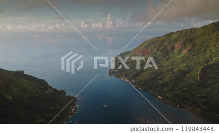 Stunning aerial shot of Moorea's Opunohu bay, vibrant green mountains, blue sea, and peaceful sunset, forming tropical haven. Wild nature paradise. Popular tourist destination, exotic summer travel 119843443