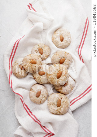 Italian almond cookies coated in powdered sugar, top view of round delicious biscuits styled on white napkin, paste di mandorle 119843568