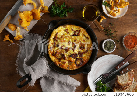 Healthy breakfast, omelette with fried seasonal forest mushrooms Chanterelles in frying pan on a wooden background with plate and cutlery, top view Healthy breakfast, omelette with fried seasonal forest mushrooms Chanterelles in frying pan on a wooden background with plate and cutlery, top view 119843609