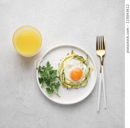 fried egg in zucchini noodle nest with sesame and juice in glass, minimalistic healthy breakfast, top view, copy space fried egg in zucchini noodle nest with sesame and juice in glass, minimalistic healthy breakfast, top view, copy space 119843612