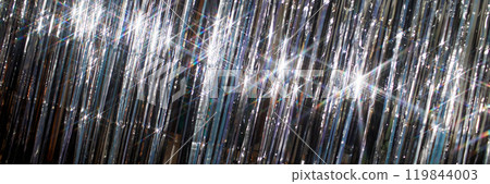 Header background shot shiny silver tinsel curtain reflecting light while decorating room for Christmas celebration Header background shot shiny silver tinsel curtain reflecting light while decorating room for Christmas celebration 119844003