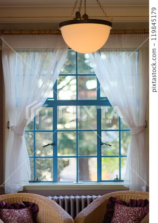 Green window frames and white curtains in a Western-style building 119845179