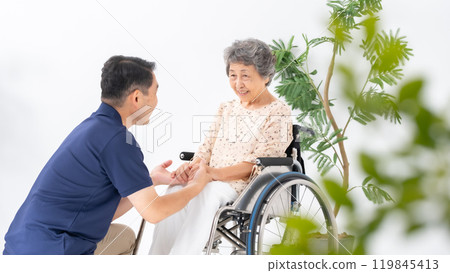 Senior woman in wheelchair and male caregiver 119845413