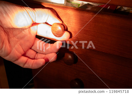 打開抽屜,同時用手電筒照亮箱子。 打開抽屜,同時用手電筒照亮箱子。 119845718