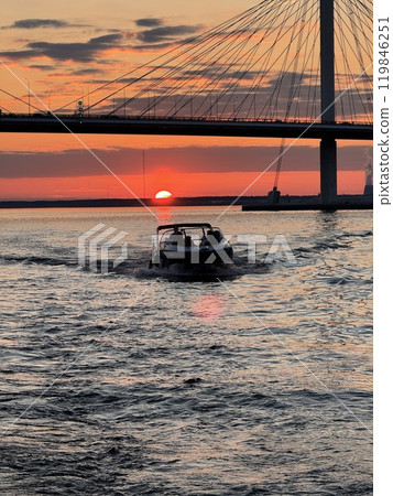 Boat Ride at Sunset Under Bridge 119846251