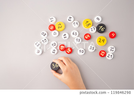 Children hands arranging plastic bottle caps with hand-written numbers and multiplication facts on a gray background. Educational math activity for kids learning and numeracy practice, Children hands arranging plastic bottle caps with hand-written numbers and multiplication facts on a gray background. Educational math activity for kids learning and numeracy practice, 119846298