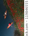 Red spider lilies blooming on the bank and a boatman rowing a boat 119846555