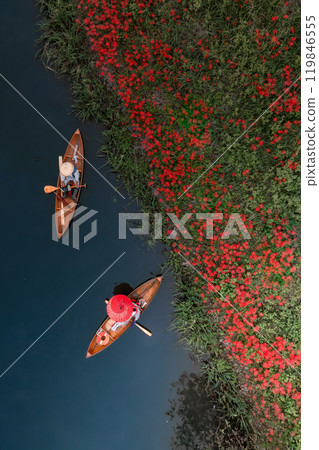 Red spider lilies blooming on the bank and a boatman rowing a boat Red spider lilies blooming on the bank and a boatman rowing a boat 119846555