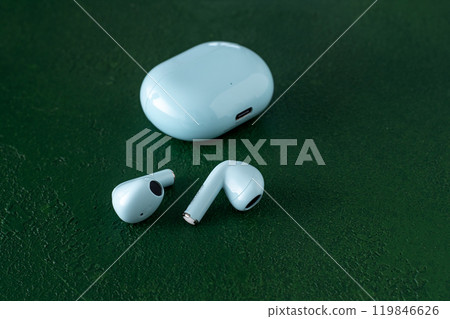 Wireless headphones on green background. Wireless, headphone in charging box. 119846626