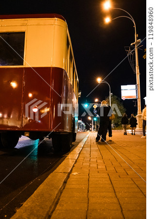 An old passenger tour bus stands at a stop in Minsk in the evening An old passenger tour bus stands at a stop in Minsk in the evening 119848960