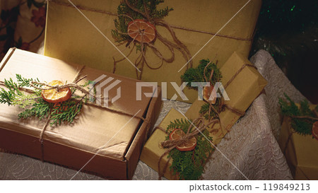 Christmas presents using recycled paper as wrappings and twine, spruce as well as dried fruit for a rustic style, zero waste and sustainable gift giving idea for the holidays Christmas presents using recycled paper as wrappings and twine, spruce as well as dried fruit for a rustic style, zero waste and sustainable gift giving idea for the holidays 119849213