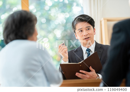A salesman explaining to a senior couple: A senior couple consulting about inheritance 119849400