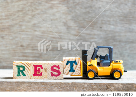 Toy forklift hold letter block t to complete word rest on wood background Toy forklift hold letter block t to complete word rest on wood background 119850010