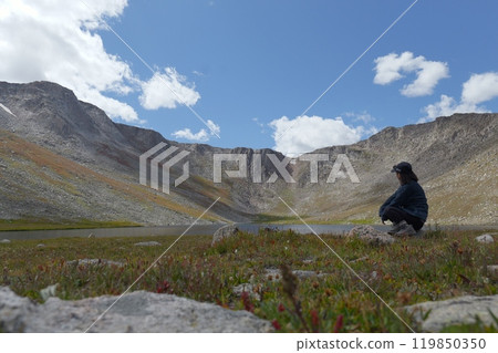 Woman standing atop the Rocky Mountains 119850350
