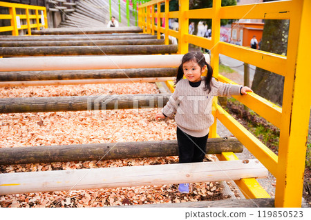 Girl playing with a log in the park 119850523