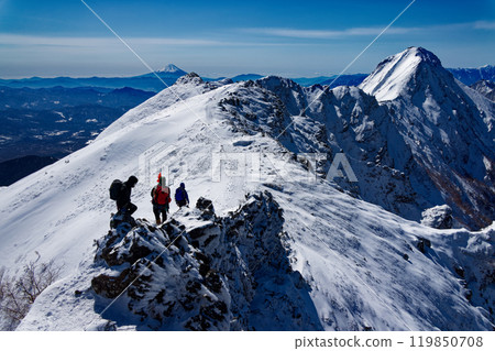 Climbers walking along the Yokodake ridgeline of the Yatsugatake mountain range in midwinter, with a view of Mount Fuji and Akadake 119850708
