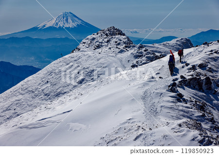 Climbers walking along the Yokodake ridgeline of the Yatsugatake mountain range in midwinter and a view of Mt. Fuji Climbers walking along the Yokodake ridgeline of the Yatsugatake mountain range in midwinter and a view of Mt. Fuji 119850923