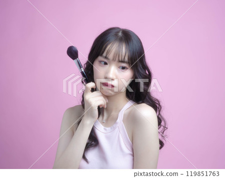 一個女人用化妝品化妝 一個女人用化妝品化妝 119851763