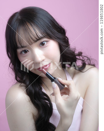 A woman applying makeup with cosmetics 119851802