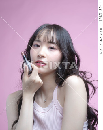 A woman applying makeup with cosmetics 119851804