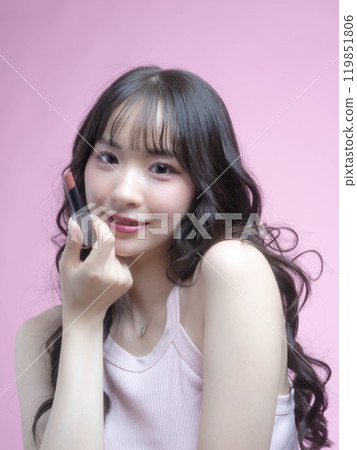 A woman applying makeup with cosmetics 119851806