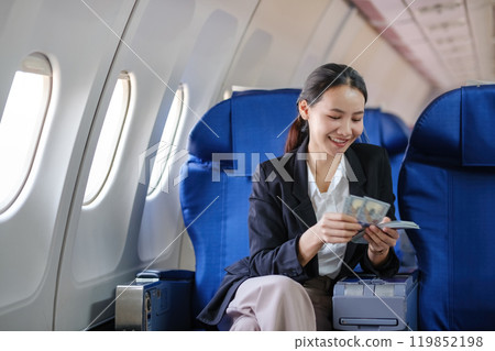 A woman sitting on an airplane with a smile on her face A woman sitting on an airplane with a smile on her face 119852198