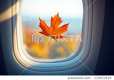 Autumn fallen maple leaf stuck on the window of an airplane. Autumn travel and flights, autumn season. Top places to travel in Fall season. Canada travel, seasonal tourism 119852624
