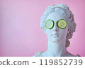 Statue of a Greek goddess with cucumber slices on eyes. Sculpture on spa treatments after bath. Beauty procedures, self-care, art, wellness, cosmetics and beauty salon, relaxation concept 119852739