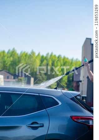 Man washing his car outside using professional special washing equipment . High quality photo 119853269