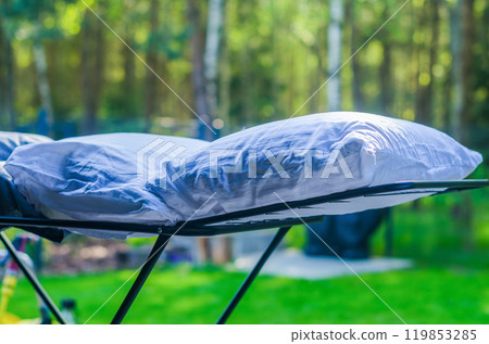 Two white down pillows are dried or ventilated in an open air in the garden. High quality photo 119853285