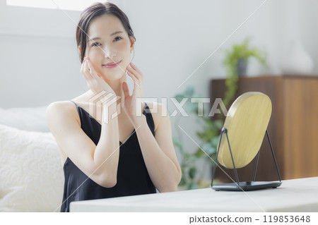 A woman doing skin care in the living room A woman doing skin care in the living room 119853648
